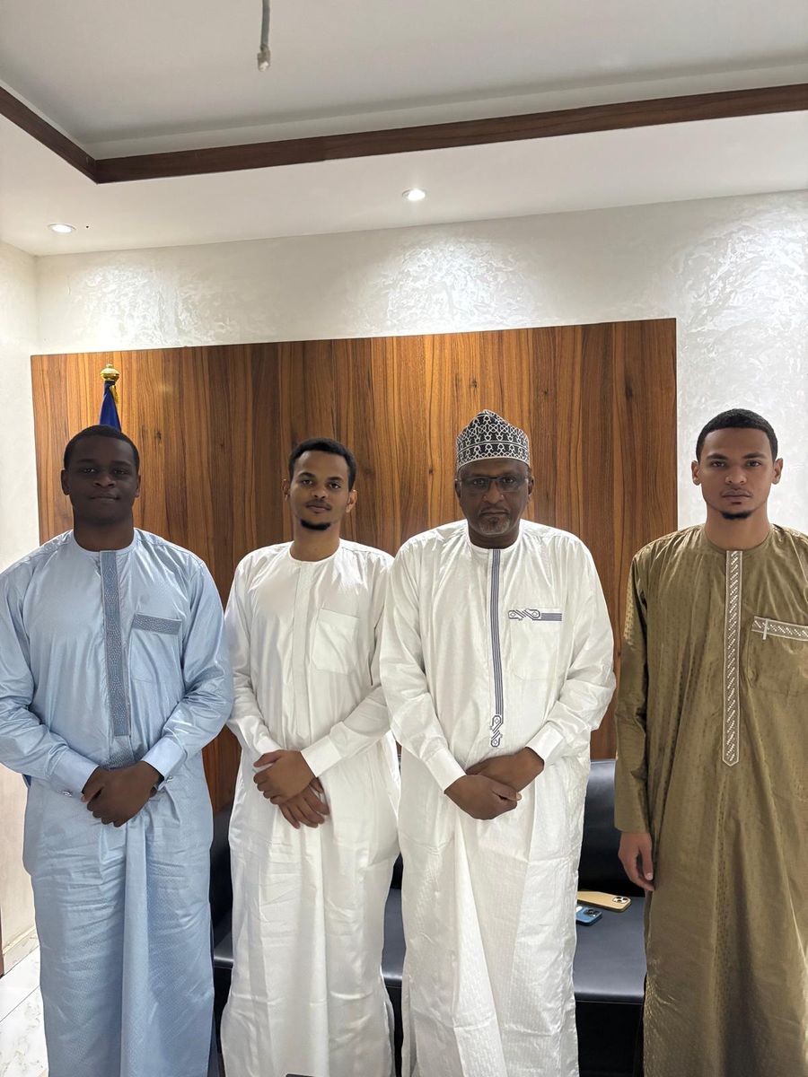 Quatre hommes debout dans un bureau : trois membres de la Prépa JBS aux côtés de Son Excellence Dr Aboubakar Assidick Choroma, ministre de l'Éducation nationale et de la Promotion civique