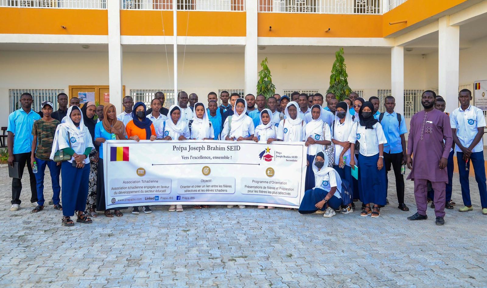 Une cinquantaine de lycéens en uniforme réunis dans la cour d'un établissement, autour de la banderole de la Prépa Joseph Brahim SEID « Vers l'excellence, ensemble ! »